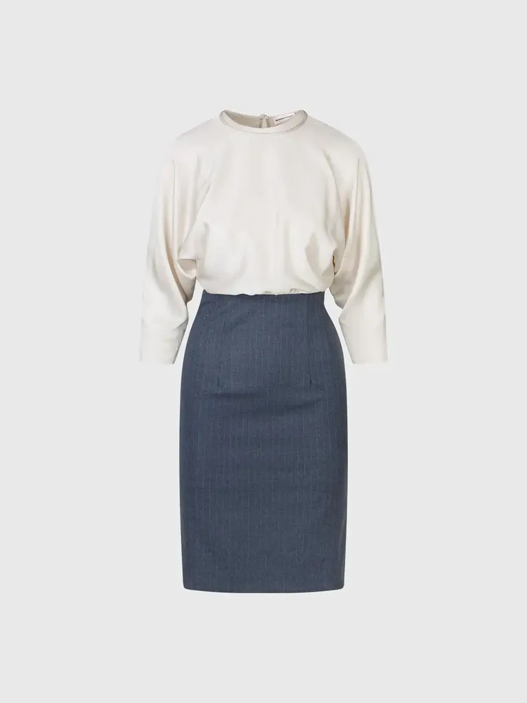 Still-life product photo of a two-tone dress with an ivory top and a blue pencil skirt